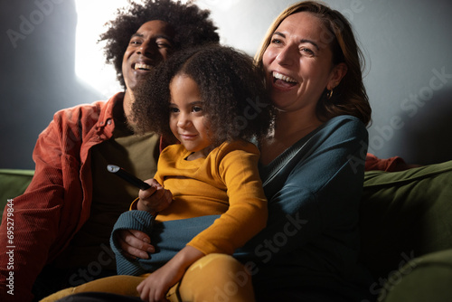 Family at home watching television together in the evening photo