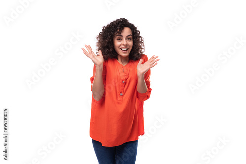 young charming brunette woman dressed in an orange blouse on a white background © Ivan Traimak