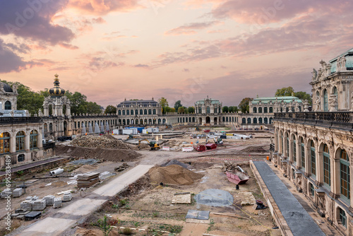 Dresden Zwinger palace king inner courtyard under reconstruction and renovation with dramatic sunset sky background. German architecture landmark building garden repair landscaping photo