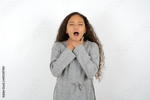 Quadro em tela Beautiful teen girl wearing  grey dress over white background shouting suffocate because painful strangle