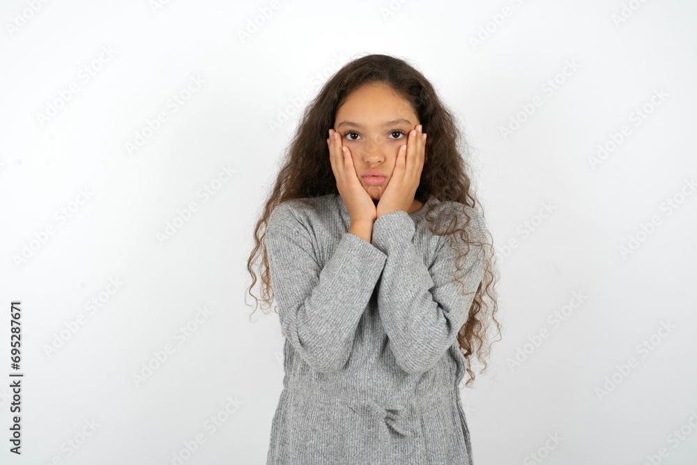 Beautiful teen girl wearing grey dress over white background Tired hands covering face, depression and sadness, upset and irritated for problem Beautiful teen girl wearing grey dress over white background Tired hands covering face, depression and sadness, upset and irritated for problem