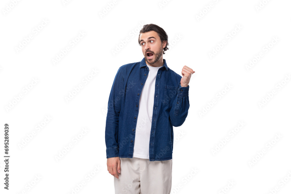 young european brunette man with a cool hairstyle is dressed in a blue denim shirt over a t-shirt young european brunette man with a cool hairstyle is dressed in a blue denim shirt over a t-shirt
