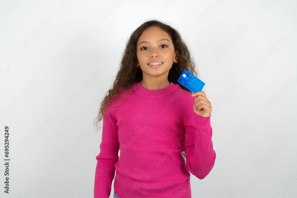 Photo of happy cheerful smiling positive Beautiful teen girl wearing pink sweater over white background recommend credit card Photo of happy cheerful smiling positive Beautiful teen girl wearing pink sweater over white background recommend credit card