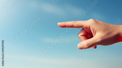 Human hand pointing to the side direction against blue sky