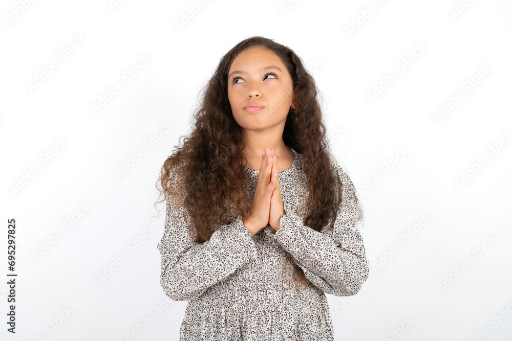 Charming cheerful Beautiful teen gil wearing gray dress over white background making up plan in mind holding hands together, setting up an idea. Charming cheerful Beautiful teen gil wearing gray dress over white background making up plan in mind holding hands together, setting up an idea.