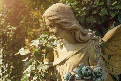 Anglel with a wreath in his hands in the rays of the sun. photo