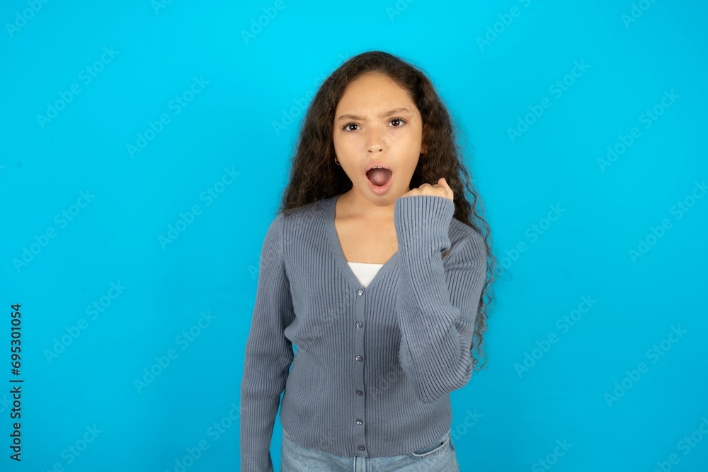 Beautiful teenager girl angry and mad raising fist frustrated and furious while shouting with anger. Rage and aggressive concept. Beautiful teenager girl angry and mad raising fist frustrated and furious while shouting with anger. Rage and aggressive concept.