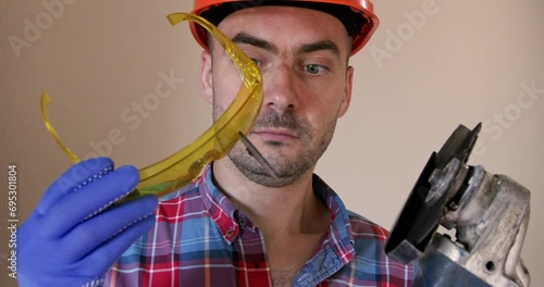 Shocked worker startled of fragment of saw disk lodged in glasses. Workman removes goggles for closer inspection along with swift resolution