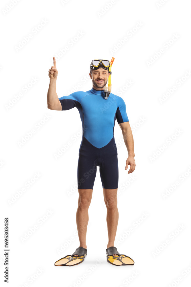 Man wearing a diving suit, mask and fins pointing up Man wearing a diving suit, mask and fins pointing up