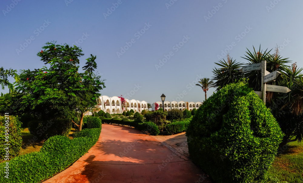 paths to white houses through a green garden in a resort from egypt panorama view