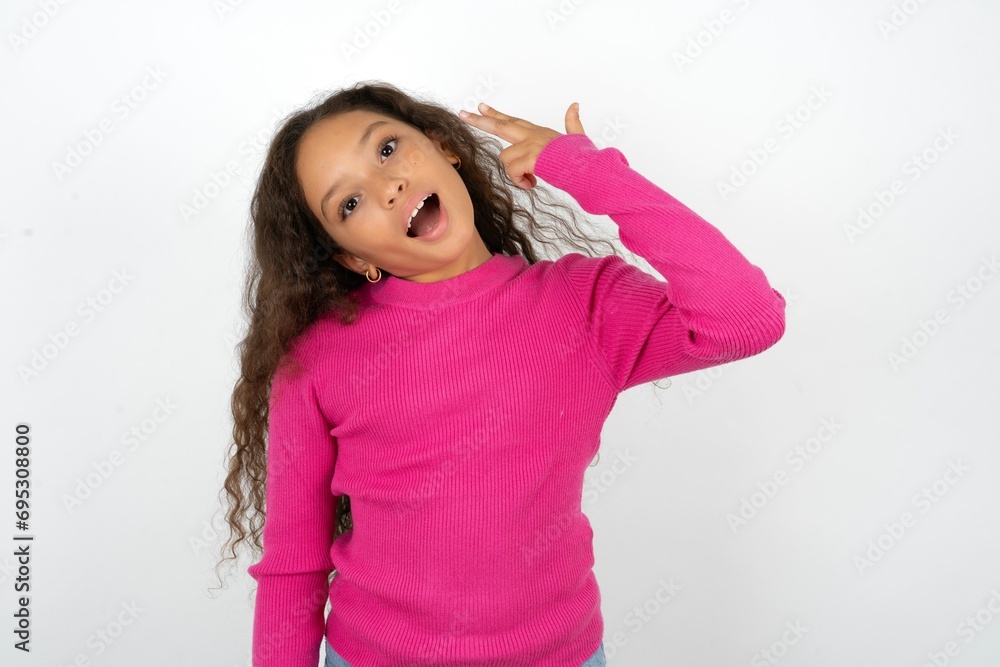 Young beautiful teen girl foolishness around shoots in temple with fingers makes suicide gesture. Funny model makes finger gun pistol Young beautiful teen girl foolishness around shoots in temple with fingers makes suicide gesture. Funny model makes finger gun pistol