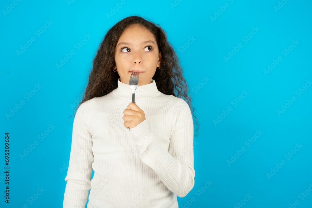 Photo of dreamy Young beautiful teen girl lick fork look empty space Photo of dreamy Young beautiful teen girl lick fork look empty space