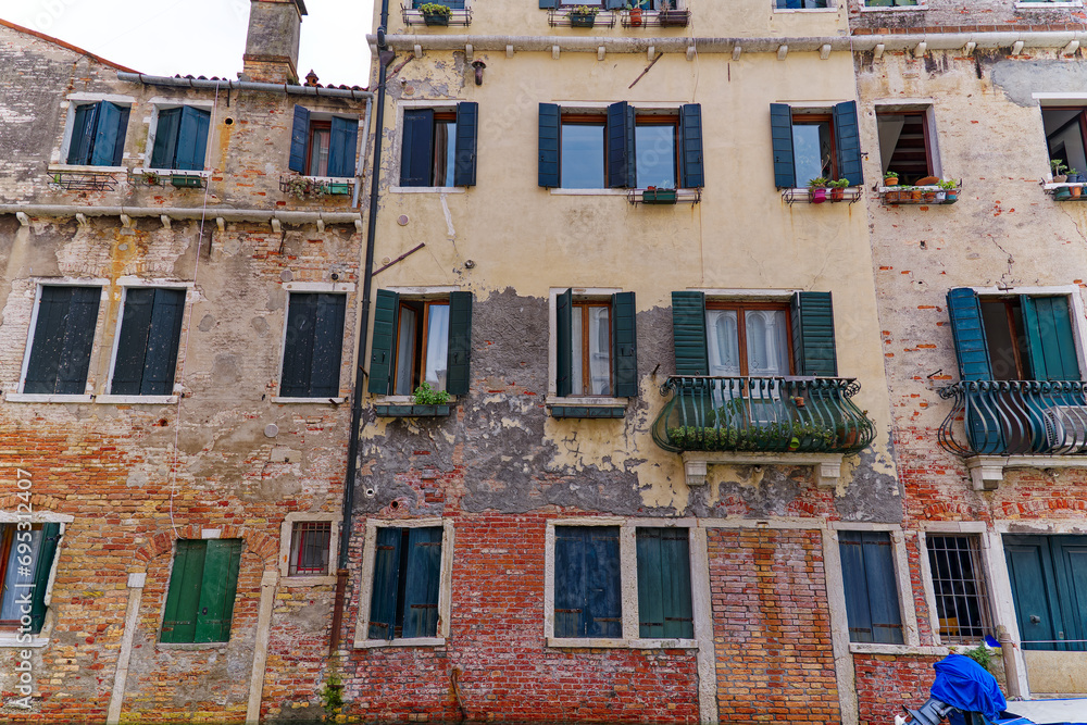 Old town of City of Venice with weathered facades on a wire on a blue cloudy summer day. Photo taken August 6th, 2023, Venice, Italy.