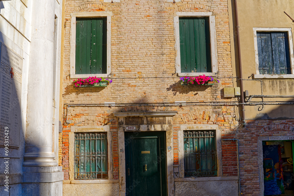 Old town of Italian City of Venice witch facade of historic houses and flower decoration on a summer day. Photo taken August 6th, 2023, Venice, Italy.