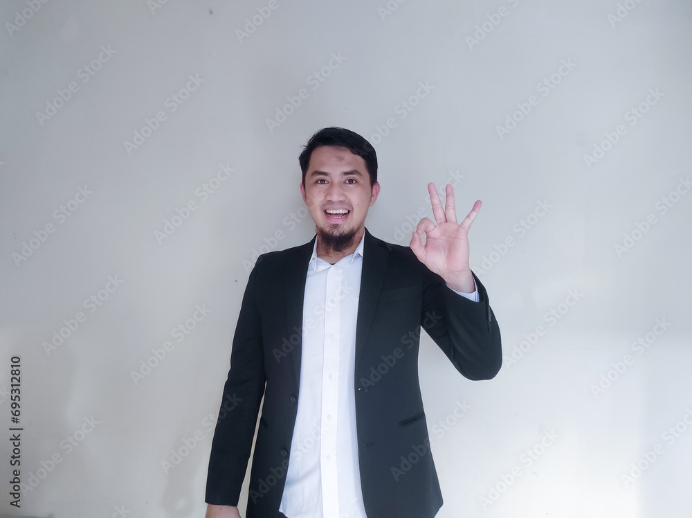 Asian businessman smiling and showing OK finger sign Asian businessman smiling and showing OK finger sign