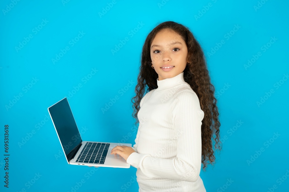Naklejka premium Adorable Young beautiful teen girl holding modern device