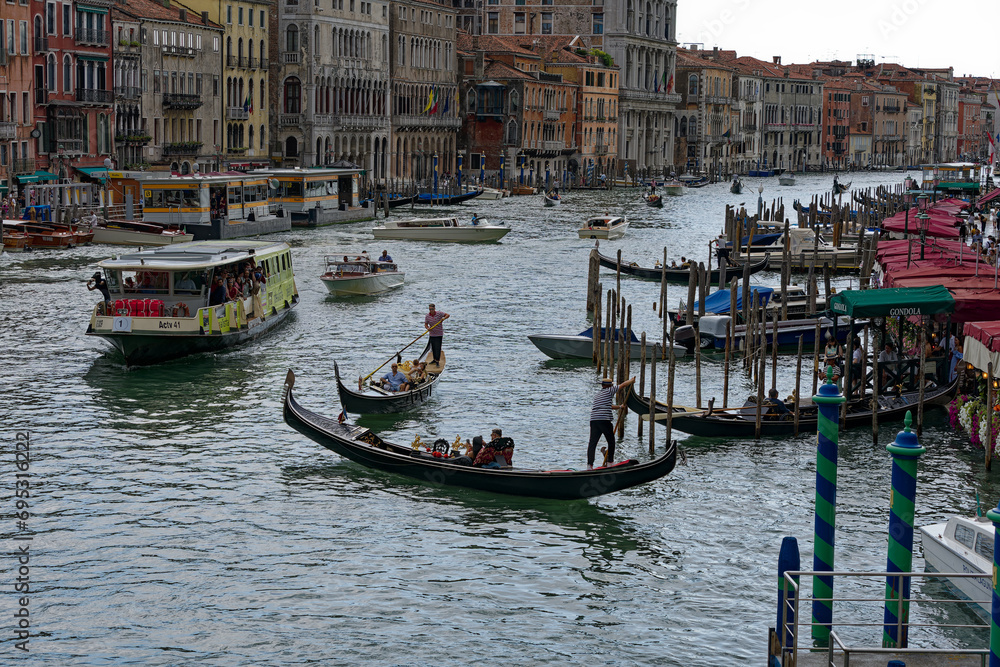 Old town of City of Venice with Grand Canal and gondolas at Rialto Pier on a blue cloudy summer day. Photo taken August 6th, 2023, Venice, Italy.