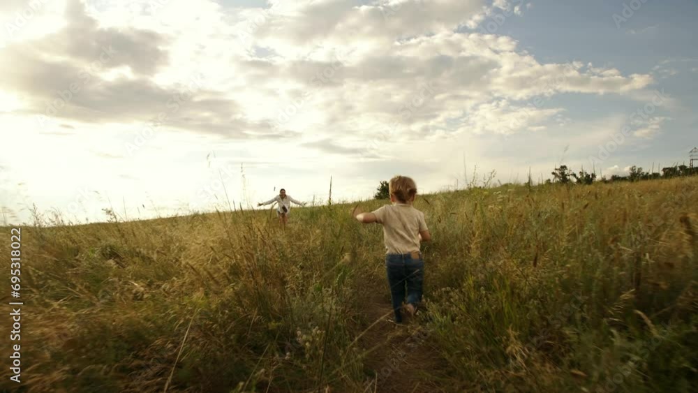 Mom plays with her little daughter in a field at sunset. The girl rejoices and smiles. A pretty young woman and her little daughter are spending time on a warm, summer evening. Mom plays with her little daughter in a field at sunset. The girl rejoices and smiles. A pretty young woman and her little daughter are spending time on a warm, summer evening.