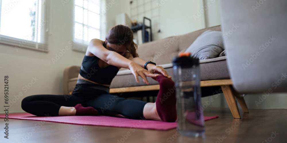 Fototapeta premium Young Asian woman meditating with trainer online at home