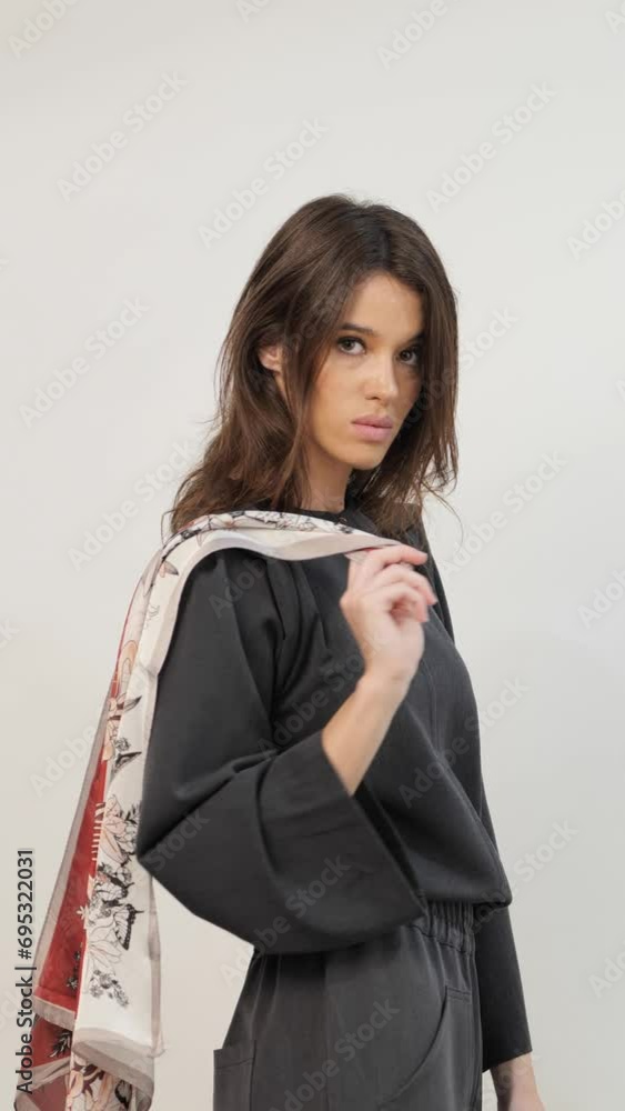 Charming female holding leaf pattern cloth in white studio Charming female holding leaf pattern cloth in white studio