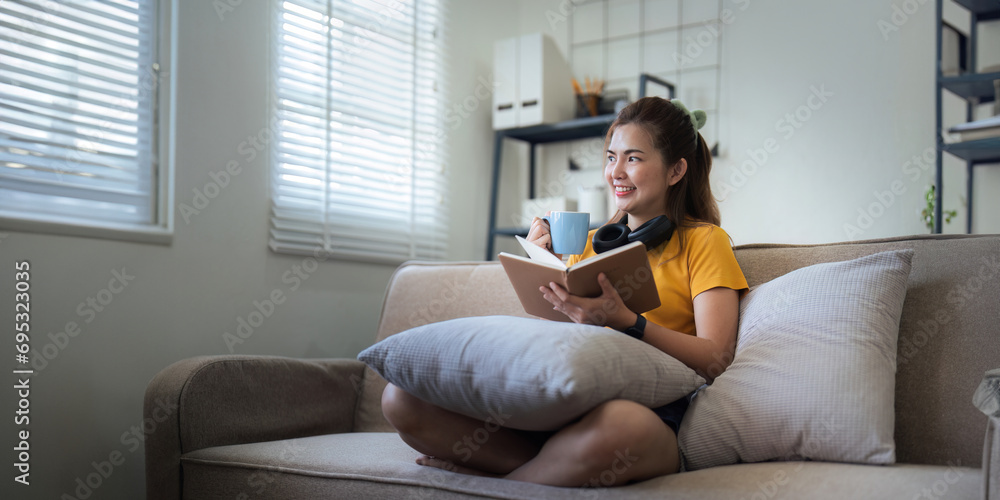Happy young woman read book on sofa at home. Lifestyle freelance relax in living room. lifestyle relaxation concept