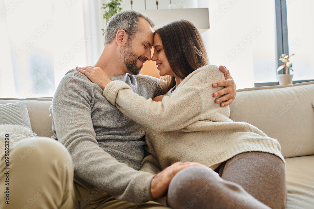 cheerful child-free couple smiling face to face with closed eyes in living room at home, serenity cheerful child-free couple smiling face to face with closed eyes in living room at home, serenity