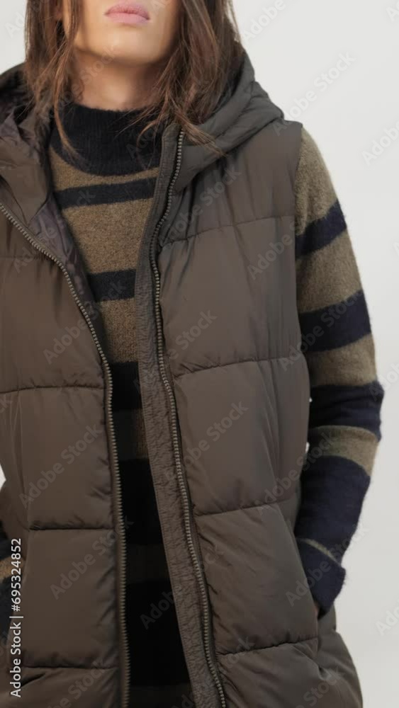 Confident female model in jacket and sweater looking at camera against white background Confident female model in jacket and sweater looking at camera against white background