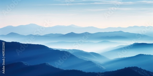 Majestic mountains under a blue sky, blending with a forested landscape during a stunning sunset. © Andrii Zastrozhnov