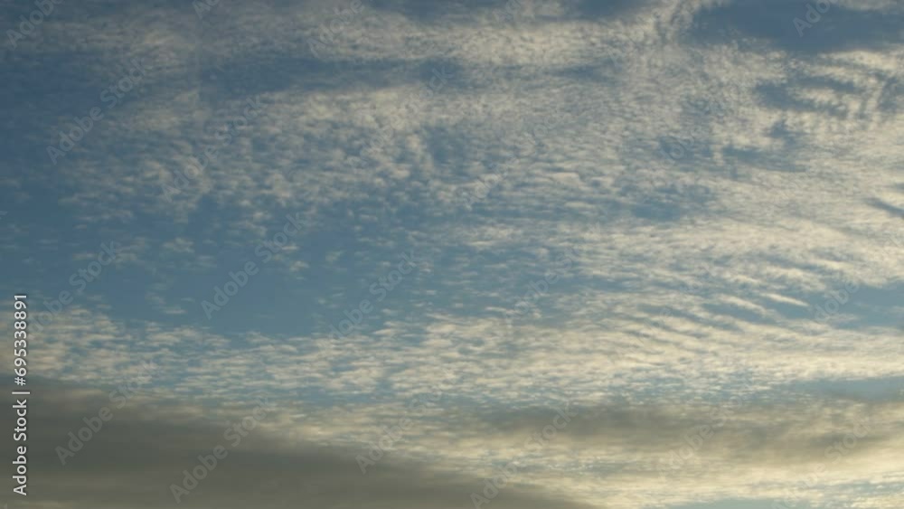 Slowly moving white altostratus and cirrus clouds over a blue sky, time lapse Slowly moving white altostratus and cirrus clouds over a blue sky, time lapse