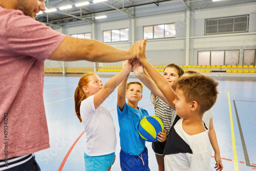 Students and teacher giving high five during gym class photo