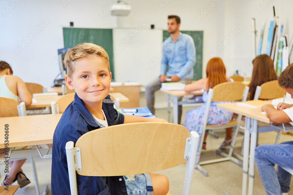 Smiling male elementary student sitting in classroom
