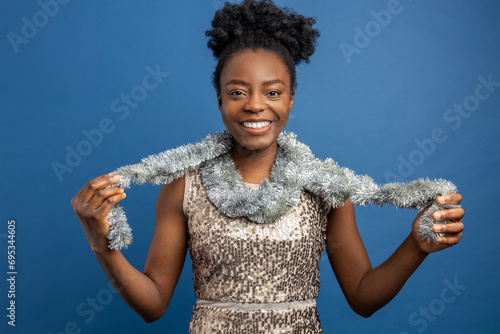 Smiling woman in golden dress and with a necklet looking enjoyed photo