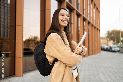 Smiling student with backpack outside college building photo