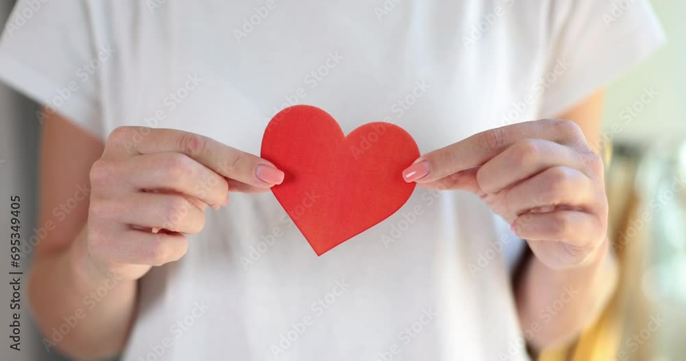 Woman holding red heart made of paper closeup. Charity volunteering and helping those in need Woman holding red heart made of paper closeup. Charity volunteering and helping those in need