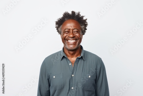 Portrait of a cheerful afro-american man in his 50s wearing a simple cotton shirt against a white background. AI Generation © Markus Schröder