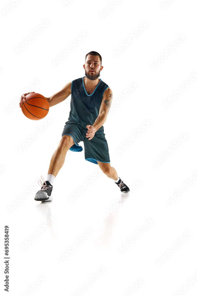 Dynamic shot capturing skilled basketball player in action, focused and determined during intense training session against white background.