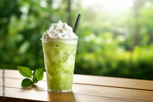 Iced green tea fresh milk with whipped cream on wooden table and blur background photo