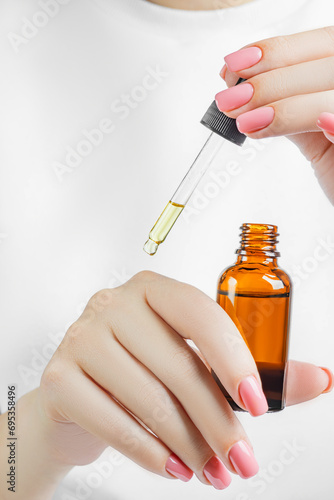 Woman applying nail oil for cuticle care photo