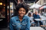 Portrait of a glad afro-american woman in her 20s sporting a versatile denim shirt against a bustling city cafe. AI Generation