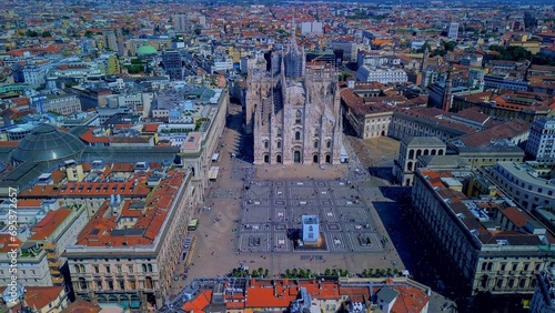 Aerial view of Piazza Duomo in front of the gothic cathedral in the center. Drone view of the gallery and rooftops during the day. Flight over the city. People in the city. Milan. Italy 15.12.2023
