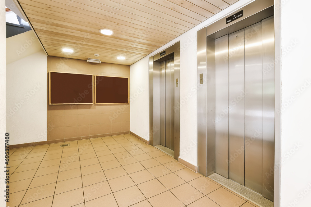Lobby with two elevators and tiled floor Lobby with two elevators and tiled floor