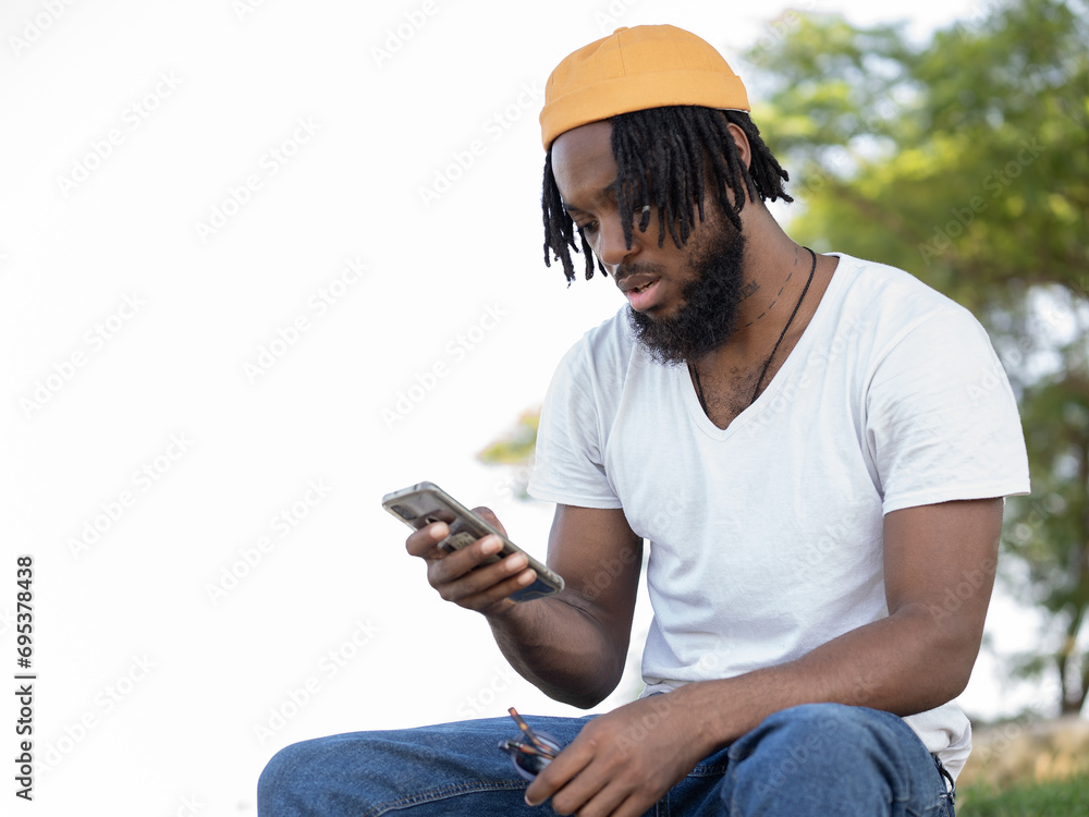 Black man messaging on smartphone in park Black man messaging on smartphone in park