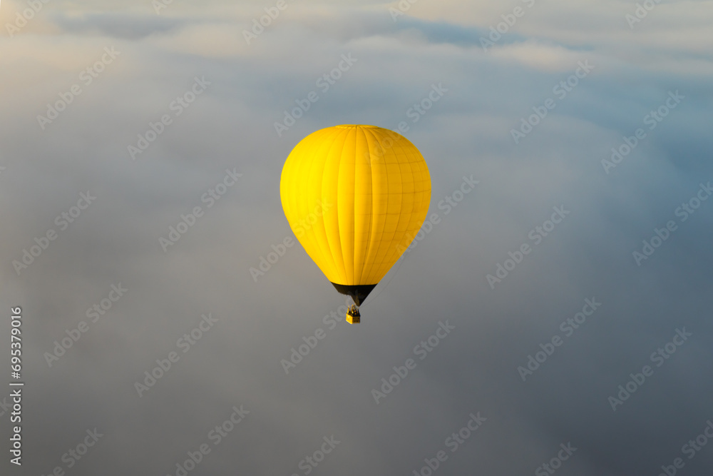 Spectacular view of hot air bright yellow balloon flying over cloudy sky in Teotihuacan Mexico Spectacular view of hot air bright yellow balloon flying over cloudy sky in Teotihuacan Mexico