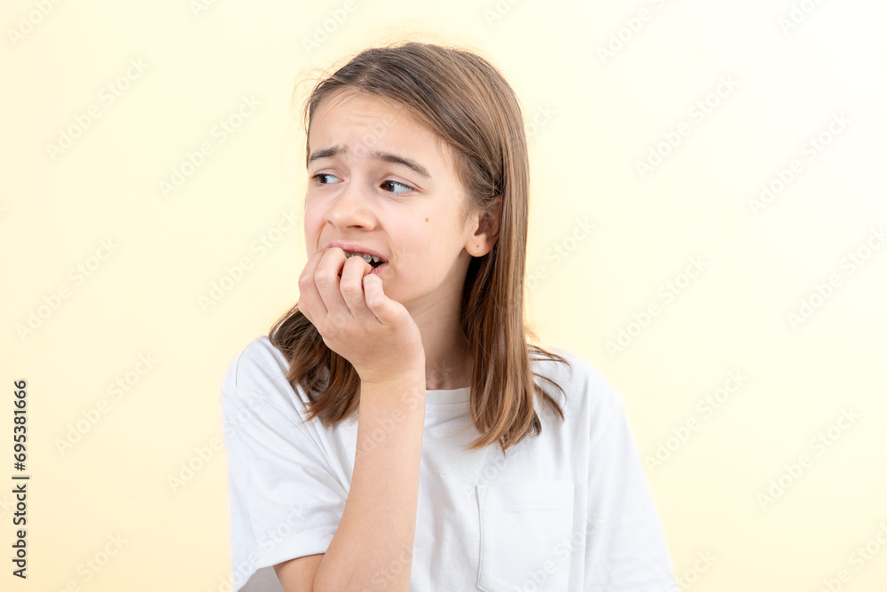 Scared and anxious girl, biting her fingernails on a white background isolated. Scared and anxious girl, biting her fingernails on a white background isolated.