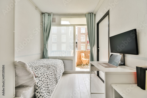 Modern small bedroom with workspace and balcony access photo