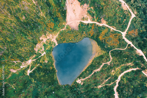 Heart shaped lake in mountains. Aerial top view, drone photo