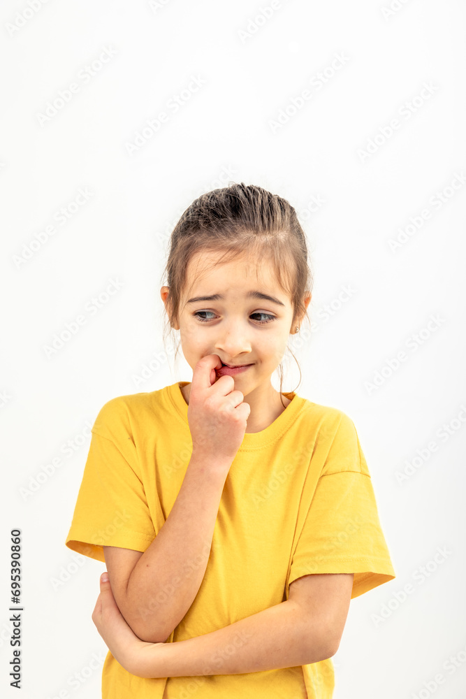 Scared and anxious girl, biting her fingernails on a white background isolated. Scared and anxious girl, biting her fingernails on a white background isolated.