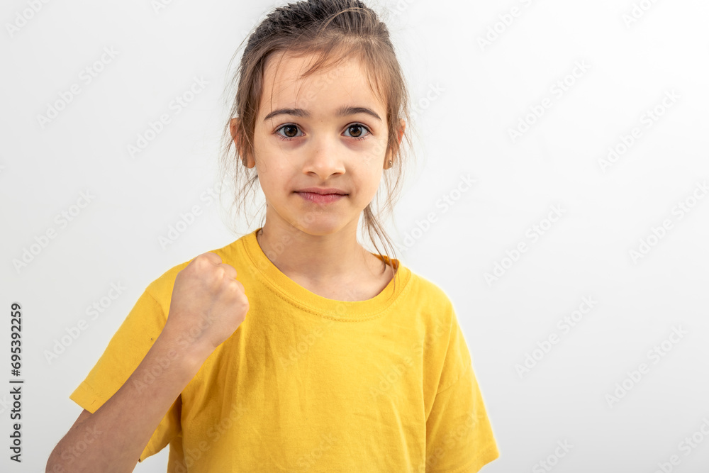 Little girl shows fist on white background isolated. Little girl shows fist on white background isolated.