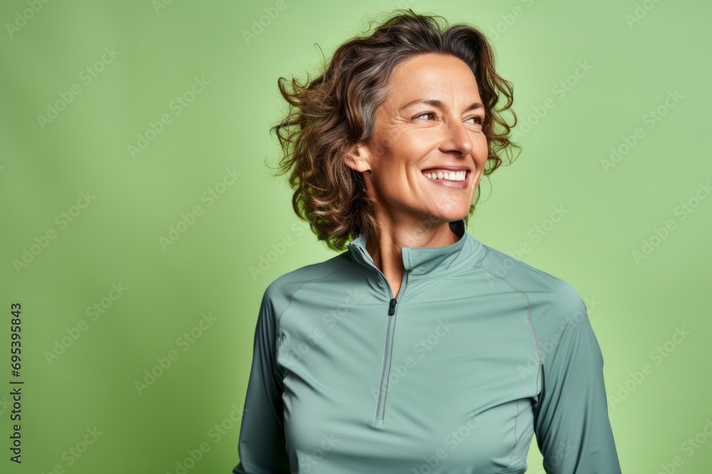 Portrait of a satisfied woman in her 50s sporting a breathable hiking shirt against a soft green background. AI Generation Portrait of a satisfied woman in her 50s sporting a breathable hiking shirt against a soft green background. AI Generation