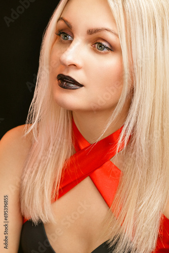 Blonde with black lips. Blonde woman with a red ribbon. Portrait of a blonde girl with bright makeup.